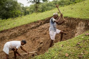 Mohan Barmal (60) and a hired labourer work on building a temple to Goddess Durga near his home at the rehabilitation site for the village of Pichhodi in Barwani, Madhya Pradesh. Part of the compensation he received is going into building the temple. September 13, 2017.