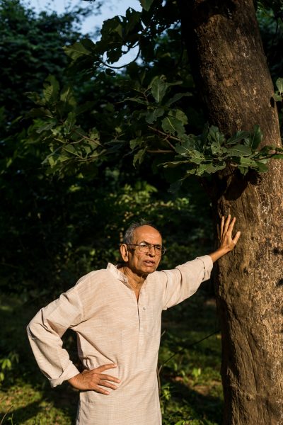 Portrait of Madhav Gadgil, Indian ecologist, academic, writer, columnist and the founder of the Centre for Ecological Sciences, photographed by Indian portrait photographer Harsha Vadlamani in Mnedha-Lekha village in Gadchiroli, Maharashtra, India for Scientific American magazine.

Madhav Gadgil is an eminent Indian ecologist, environmentalist, and academician. Known for his extensive research and contributions to the field of environmental science, Gadgil has played a crucial role in shaping environmental policies and conservation strategies in India.

With a deep understanding of ecological systems and their interdependencies, Madhav Gadgil has worked tirelessly to promote sustainable development practices and preserve biodiversity. His groundbreaking work on the Western Ghats ecology and the concept of "People's Biodiversity Registers" has received widespread acclaim.

Gadgil's vision for ecological sustainability encompasses the harmonious coexistence of humans and nature. He has emphasized the importance of community participation, local knowledge, and ecosystem-based approaches in environmental conservation.

As an advocate for environmental justice and equitable resource distribution, Madhav Gadgil has actively engaged with policymakers, scientists, and local communities to promote ecologically sensitive practices. His efforts have had a profound impact on shaping environmental policies and fostering public awareness about the need for sustainable development.

Through his research, publications, and engagements, Madhav Gadgil continues to inspire individuals and organizations to take proactive measures in preserving the environment and creating a more sustainable future for generations to come.

Experience the captivating presence of Madhav Gadgil, renowned environmentalist, as he stands under a majestic Mahua tree in the remarkable village of Mendha Lekha. This striking photograph, captured by the talented Harsha Vadlamani, beautifully depicts Gadgil's deep connection with nature and his tireless efforts in environmental conservation.

The image showcases the harmonious blend of Gadgil's persona with the serene surroundings of Mendha Lekha, one of the first villages in India to receive community forest rights under the forest righst act. The Mahua tree symbolizes the rich biodiversity and cultural heritage of the village, while Gadgil's presence reflects his passion and commitment to sustainable development.

Harsha Vadlamani's artistic composition and attention to detail highlight the essence of this unique moment, capturing Gadgil's wisdom and reverence for the natural world. The photograph serves as a visual narrative, inspiring viewers to appreciate the beauty of nature and recognize the importance of preserving our ecosystems.