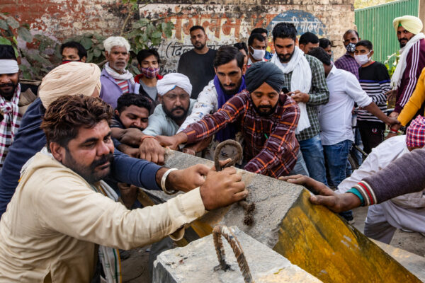 Farmers remove police barricades put up on one of the roads that lead to the protest site at Singhu. December 08, 2020.