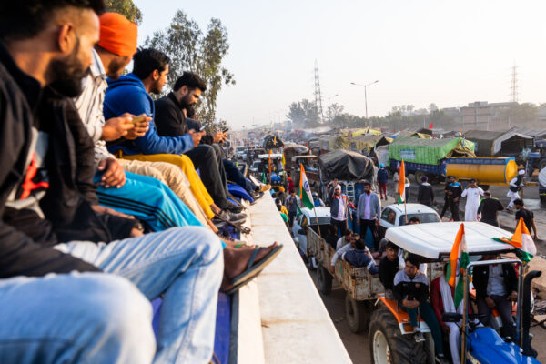 A group of protestors who have just arrived from Punjab watch from the top of their bus as it makes its way past tractors at Singhu. December 08, 2020.