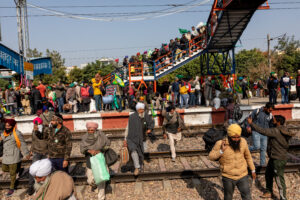 Farmers who have just arrived by train from Punjab cross the tracks toward the protest site at Tikri. Every day, a certain number of farmers head back to the village to tend to their fields or for some other work at home, and the same number of people from each village take their place at the protest site. December 16, 2020.