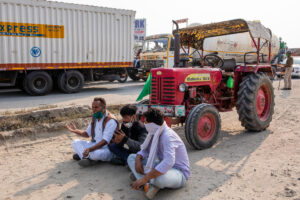 Banwari Kudi, extreme left, the first farmer from Rajasthan to reach the border with Haryana, sits down in protest as the police stop him from proceeding towards Delhi. December 12, 2020.