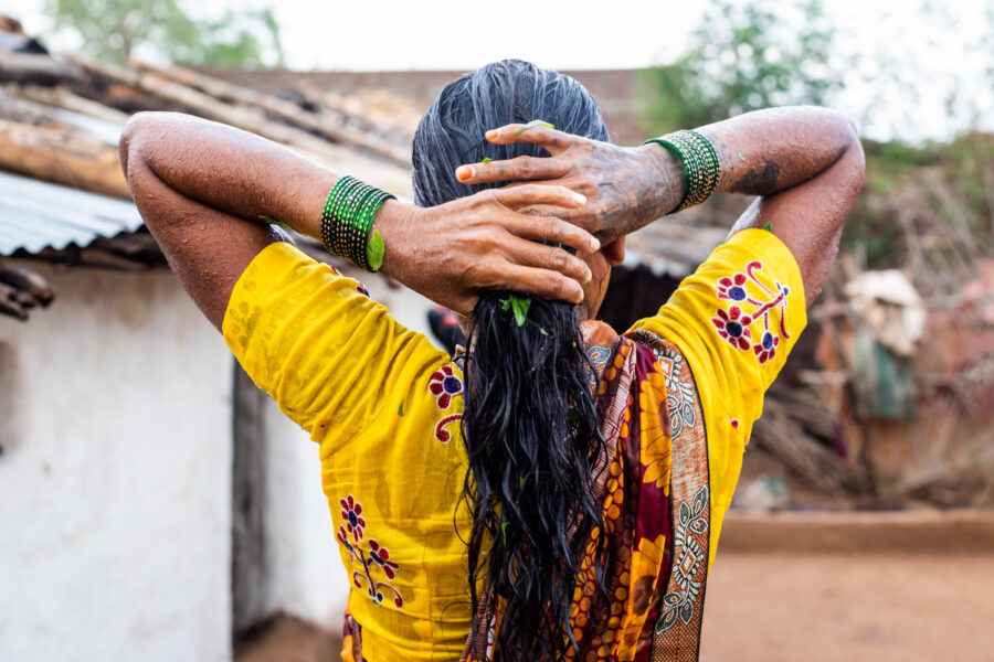 Sojar Chintaram Bilavekar takes a ritual purification bath with neem, tulsi and bel leaves upon reaching home in Dadida in the Melghat region of Amravati, Maharashtra. She spent INR 6000 on treatment for fever from a quack, who told her she had typhoid. But when it did not subside even after many days, she travelled to the sub-divisional hospital in Dharni, where she tested positive for COVID-19. She spent 19 days there, 16 of them on oxygen support. May 30, 2021.