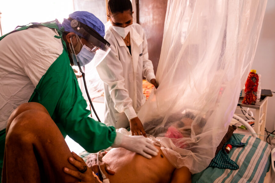 Dr Ashish Satav, 49, checks on Sonaji Savalkar, 60, who tested positive for COVID-19 at the MAHAN Trust’s hospital in Utavali in the Melghat region of Amravati, Maharashtra. The plastic sheets used when Satav visited the patient were intended to prevent the hospital’s only senior doctor handling COVID-19 cases from catching an infection. May 31, 2021.