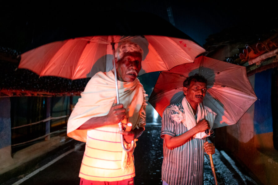 Village elders watch as Rajesh Vishwakarma, 30 and his wife Surekha Bai, 25, carry their dead infant home in Gidhali from Shaheed Hospital in Dalli Rajhara in Balod, Chhattisgarh. The infant, delivered in a PHC closer to their village, was brought to the hospital with complications arising from drinking amniotic fluid but died before the family could arrange for money for a private ambulance to a better equipped hospital at Durg, 85 kilometres away. June 14, 2021.