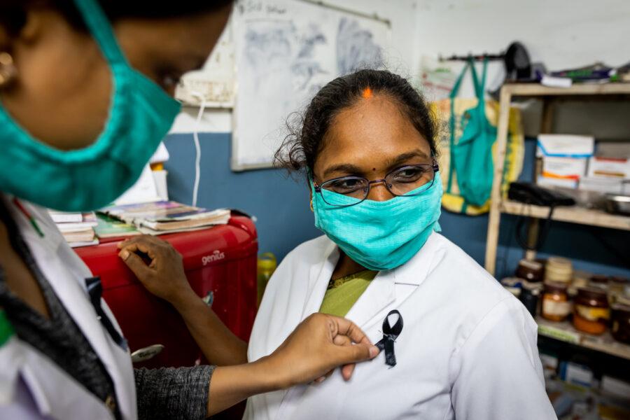 Ruchika Behera, 26, pins a black band on a fellow nurse Sarita Yadav, 35, as the medical staff join a nationwide protest by medical professionals against attacks by patients and their relatives on them, at Shaheed Hospital in Dalli Rajhara in Balod, Chhattisgarh. June 18, 2021.