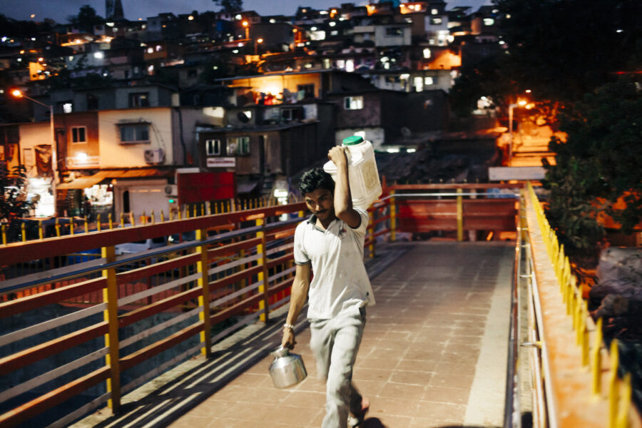 A farmer returning from work carries along water to his tent at the camp in Ghatkopar, Mumbai.